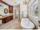 Bright bathroom featuring a soaking tub, granite countertops, dark wood cabinetry, and updated finishes at 13917 8Th St, Dade City, FL 33525