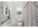 Bathroom with pedestal sink, neutral paint, updated finishes, and patterned shower curtain at 13917 8Th St, Dade City, FL 33525