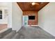 Spacious bonus room features tile flooring, wood paneled ceiling, TV, and view to adjacent rooms at 13917 8Th St, Dade City, FL 33525