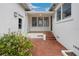 Charming brick courtyard with colorful foliage, leading to a white home's entrance at 13917 8Th St, Dade City, FL 33525