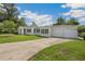 Attractive white single-story home with a three car garage and a well maintained lawn at 13917 8Th St, Dade City, FL 33525