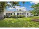Charming white home with lush green lawn, brick pathway, manicured shrubbery, and black window shutters at 13917 8Th St, Dade City, FL 33525