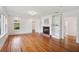 Bright living room featuring hardwood floors, fireplace, and built-in bookshelves at 13917 8Th St, Dade City, FL 33525
