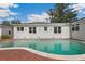 Backyard swimming pool with brick patio and white stucco home exterior on a sunny day at 13917 8Th St, Dade City, FL 33525