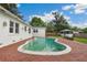 Backyard swimming pool with brick patio and white stucco home exterior on a sunny day at 13917 8Th St, Dade City, FL 33525