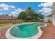 Backyard in-ground pool featuring a brick surround, lush landscaping, and ample sunlight at 13917 8Th St, Dade City, FL 33525