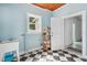 Bright utility room with black and white tile floor, utility sink, window, and access to another room at 13917 8Th St, Dade City, FL 33525