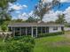 A cozy screened-in patio is perfect for relaxing outdoors in this backyard with mature landscaping at 140 Morrow Cir, Brandon, FL 33510