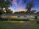 A cozy screened-in patio is perfect for relaxing outdoors in this backyard with mature landscaping and fire pit at 140 Morrow Cir, Brandon, FL 33510