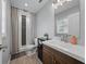 Well-lit bathroom with a shower featuring stone tile and wood-look floors, plus a vanity with stylish cabinetry at 140 Morrow Cir, Brandon, FL 33510