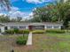 Charming single story home featuring a manicured lawn, neat landscaping and a welcoming walkway to the front door at 140 Morrow Cir, Brandon, FL 33510