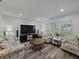 Bright living room with floral furniture, a large television and plank flooring at 140 Morrow Cir, Brandon, FL 33510