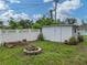 A well-maintained shed sits on a spacious backyard with a stone fire pit, gardening beds, and fenced perimeter at 140 Morrow Cir, Brandon, FL 33510