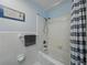 Bright bathroom featuring a white tile shower/tub combo with bronze fixtures and decorative elements at 140 Morrow Cir, Brandon, FL 33510
