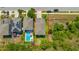 Aerial view of a modern home with a long driveway and ample yard space bordered by lush greenery at 14716 Crescent Rock Dr, Wimauma, FL 33598