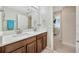 Bathroom with double sinks, vanity, and view to hall at 14716 Crescent Rock Dr, Wimauma, FL 33598