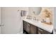 Elegant bathroom featuring a wood-look accent wall and a modern vanity with white countertop at 14716 Crescent Rock Dr, Wimauma, FL 33598