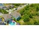 A modern home with lawn, and a neighboring yard featuring a pool for outdoor living and relaxation at 14716 Crescent Rock Dr, Wimauma, FL 33598