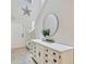 Bright foyer with a decorative star, a round mirror, and an elegant white dresser at 14716 Crescent Rock Dr, Wimauma, FL 33598