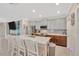 Modern kitchen with a large island, stainless steel appliances, and seamless flow into the living area at 14716 Crescent Rock Dr, Wimauma, FL 33598