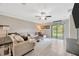 Comfortable living room with a large sectional sofa, stylish decor, and sliding glass doors at 14716 Crescent Rock Dr, Wimauma, FL 33598