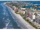 Beautiful aerial view of the oceanfront condo building with a long sandy beach and clear blue water at 15000 Gulf Blvd # 407, Madeira Beach, FL 33708