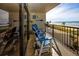 Inviting balcony featuring cozy blue Adirondack chairs with stunning views of the ocean and sandy beach at 15000 Gulf Blvd # 407, Madeira Beach, FL 33708