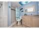 A colorful bathroom with a tiled shower, a sink with a mirror, and coastal themed decor at 15000 Gulf Blvd # 407, Madeira Beach, FL 33708