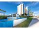 Well-maintained condo building exterior with lush landscaping, a water fountain, and a clear blue sky at 15000 Gulf Blvd # 407, Madeira Beach, FL 33708
