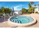 Inviting hot tub surrounded by lush landscaping, lounge chairs, and a bright blue umbrella, perfect for relaxation at 15000 Gulf Blvd # 407, Madeira Beach, FL 33708