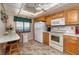 Well-lit kitchen with tile floors, white appliances, and a breakfast table with a view of the outside at 15000 Gulf Blvd # 407, Madeira Beach, FL 33708