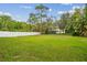 Large backyard featuring healthy grass and a white fence surrounded by many trees at 15709 Leatherleaf Ln, Land O Lakes, FL 34638