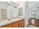 Bathroom featuring dual sinks, walk-in shower and views to the bedroom at 15709 Leatherleaf Ln, Land O Lakes, FL 34638