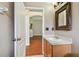 Bathroom featuring a wooden vanity and sink with a decorative mirror, flowing into the home's open interior at 15709 Leatherleaf Ln, Land O Lakes, FL 34638