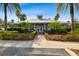 View of the clubhouse featuring blue accents, palm trees, and a sidewalk at 15709 Leatherleaf Ln, Land O Lakes, FL 34638