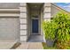 Inviting front entryway with a blue door framed by decorative white pillars and lush plants at 15709 Leatherleaf Ln, Land O Lakes, FL 34638