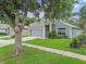 Well-maintained home featuring a gray exterior, green lawn, and two car garage at 15709 Leatherleaf Ln, Land O Lakes, FL 34638