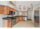 A view of the open-concept kitchen featuring wooden cabinets and modern appliances at 15709 Leatherleaf Ln, Land O Lakes, FL 34638