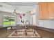 Close-up of the stainless steel kitchen sink with a view of the backyard through sliding glass doors at 15709 Leatherleaf Ln, Land O Lakes, FL 34638