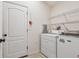 Functional laundry room with modern appliances, shelving, and door to the exterior at 15709 Leatherleaf Ln, Land O Lakes, FL 34638