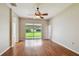 Bright living room featuring wood floors, a ceiling fan, and sliding glass doors to the backyard at 15709 Leatherleaf Ln, Land O Lakes, FL 34638