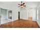 A spacious main bedroom featuring hardwood floors, a ceiling fan, and a sliding glass door to the patio at 15709 Leatherleaf Ln, Land O Lakes, FL 34638