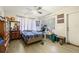 Bright bedroom featuring wood-look floors, ceiling fan and a window with natural light at 1607 Bell Shoals Rd, Brandon, FL 33511