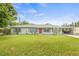 Charming single-story home with a well-maintained lawn, complemented by a red front door and a convenient carport at 1607 Bell Shoals Rd, Brandon, FL 33511