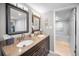 Bathroom featuring double sinks, granite countertops, dark wood cabinets, and marble flooring into the shower at 1621 Gulf Blvd # 407, Clearwater Beach, FL 33767