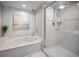Bright bathroom features a marble tub, glass shower, and elegant tile flooring at 1621 Gulf Blvd # 407, Clearwater Beach, FL 33767