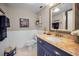 Bathroom with blue vanity, granite countertop, and white wainscoting at 1621 Gulf Blvd # 407, Clearwater Beach, FL 33767