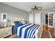 Bedroom with light and airy decor featuring a decorative ceiling fan and french doors leading to a balcony at 1621 Gulf Blvd # 407, Clearwater Beach, FL 33767