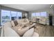 Bright living room featuring a large sectional sofa, expansive windows, and stylish decor at 1621 Gulf Blvd # 407, Clearwater Beach, FL 33767