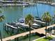 Waterfront view of the marina with boats docked along a wooden pier and palm trees at 1621 Gulf Blvd # 407, Clearwater Beach, FL 33767